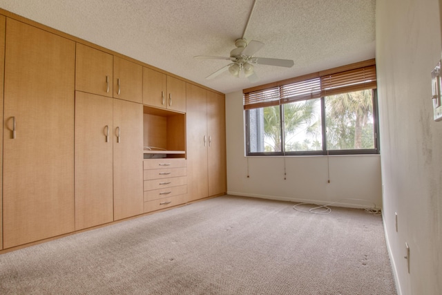 unfurnished bedroom with ceiling fan, light carpet, a textured ceiling, and a closet