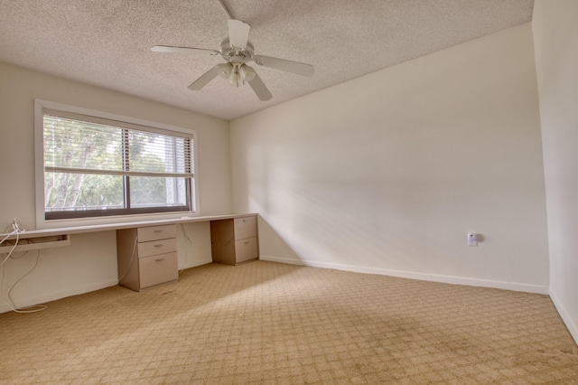 unfurnished office featuring ceiling fan, light colored carpet, and a textured ceiling