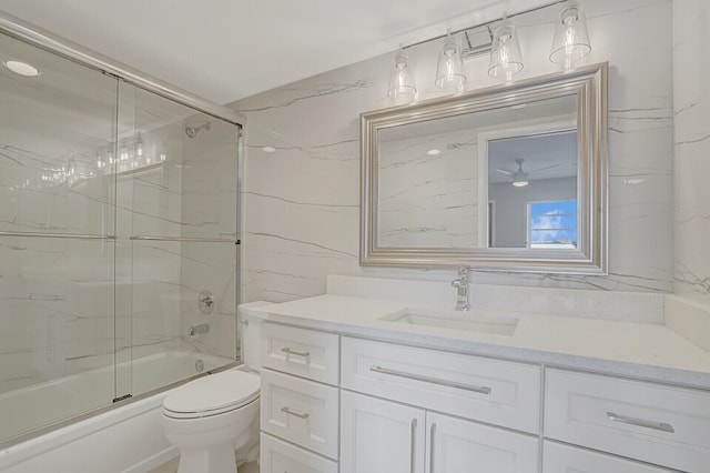 full bathroom featuring enclosed tub / shower combo, vanity, and toilet