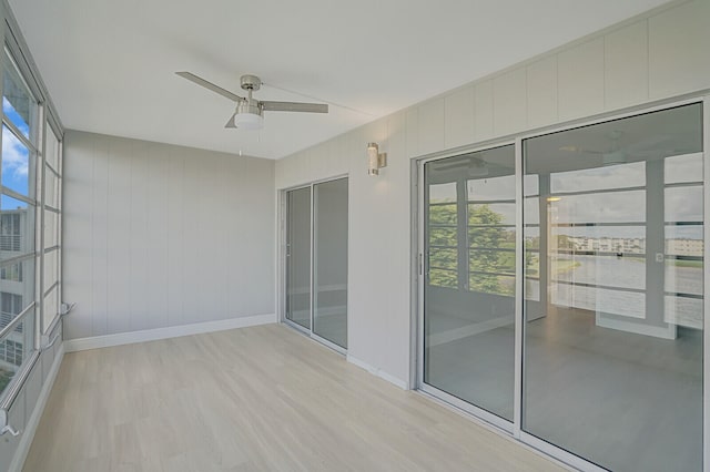 unfurnished sunroom with ceiling fan