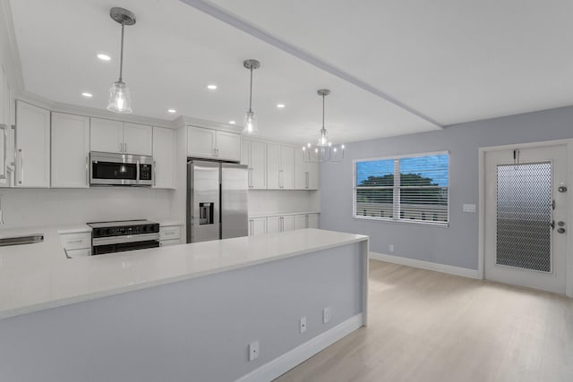 kitchen featuring stainless steel appliances, hanging light fixtures, white cabinetry, and light hardwood / wood-style flooring