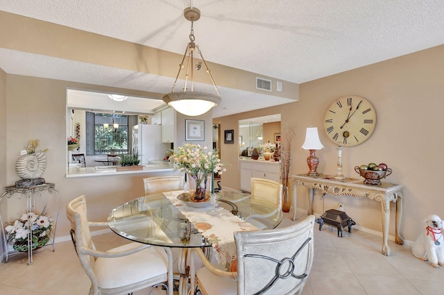 dining space featuring light tile patterned floors and a textured ceiling