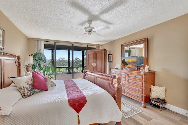 bedroom with access to outside, ceiling fan, floor to ceiling windows, a textured ceiling, and light hardwood / wood-style flooring