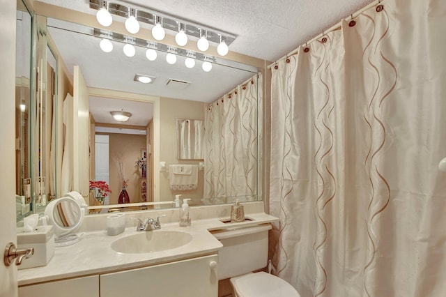 bathroom featuring vanity, toilet, and a textured ceiling