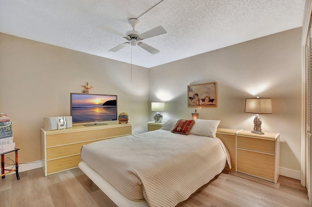 bedroom featuring ceiling fan, a textured ceiling, and light hardwood / wood-style floors