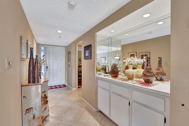 bathroom featuring tile patterned flooring, vanity, and a textured ceiling