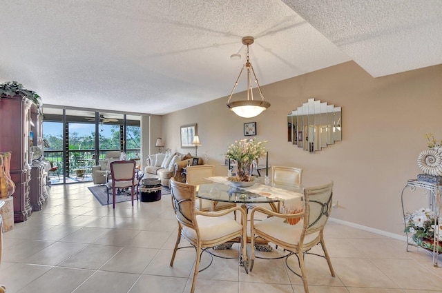 tiled dining room featuring a wall of windows and a textured ceiling