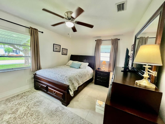 tiled bedroom featuring multiple windows and ceiling fan