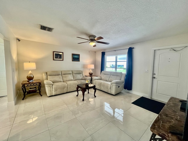 tiled living room with a textured ceiling and ceiling fan