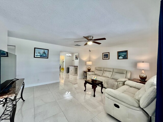 living room with light tile patterned floors, a textured ceiling, and ceiling fan