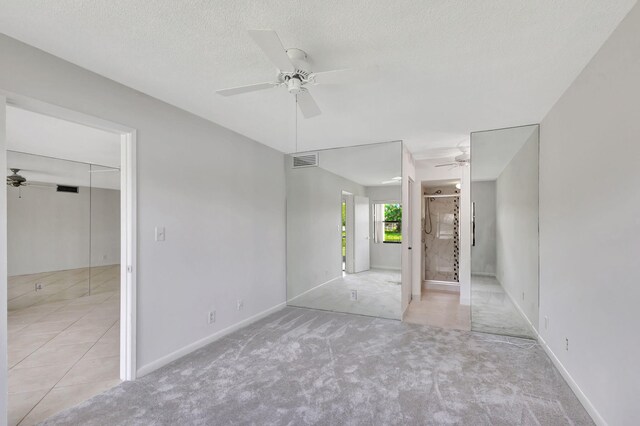 bathroom with walk in shower, toilet, vanity, ceiling fan, and tile patterned floors