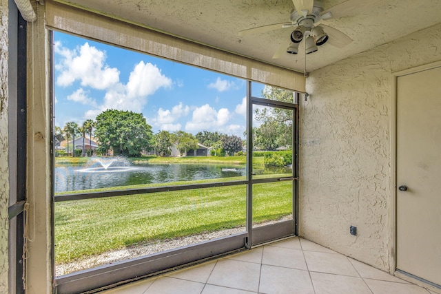 unfurnished sunroom featuring a water view and ceiling fan