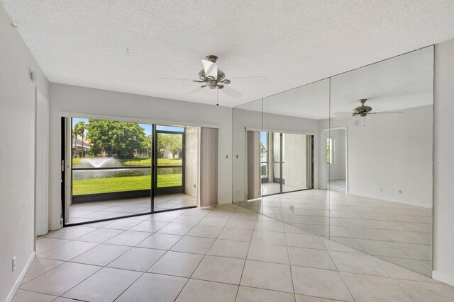 unfurnished sunroom featuring a water view and ceiling fan