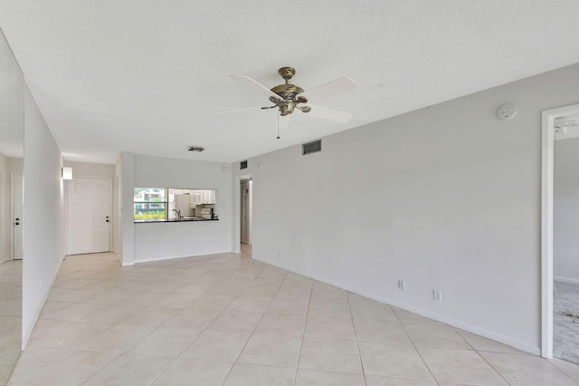 unfurnished room featuring light tile patterned floors, a textured ceiling, and ceiling fan