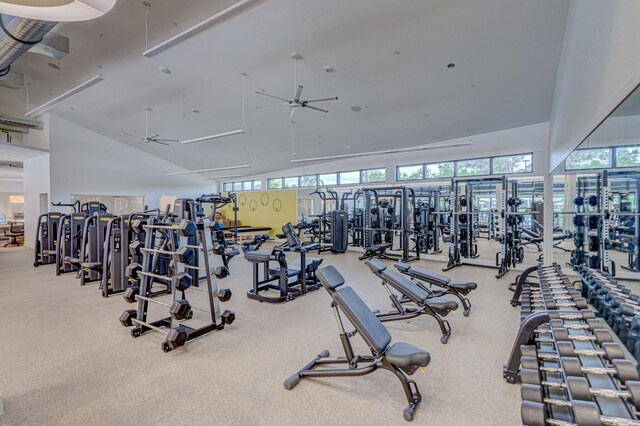 gym with light colored carpet, high vaulted ceiling, and ceiling fan