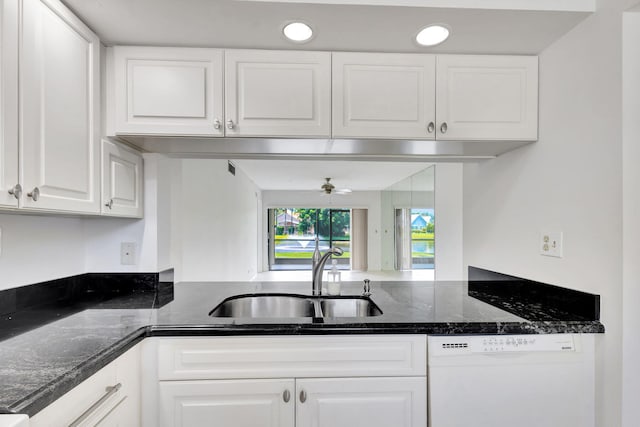 kitchen with sink, dishwasher, dark stone counters, and white cabinetry