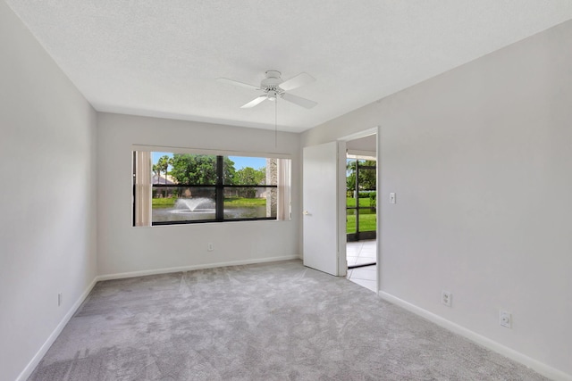 carpeted empty room with a textured ceiling and ceiling fan