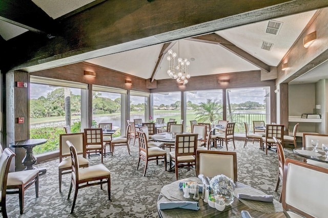 sunroom featuring a notable chandelier and vaulted ceiling with beams