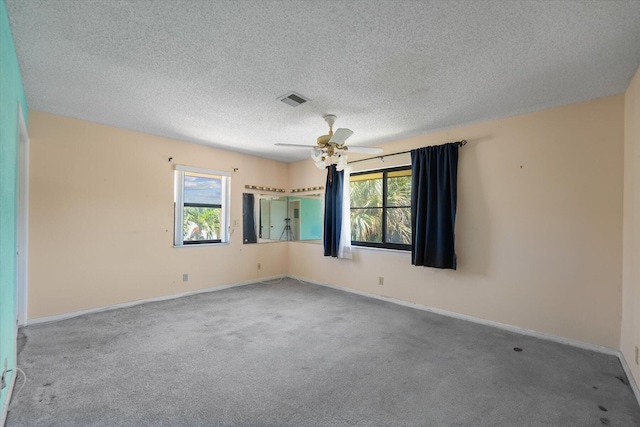 carpeted spare room featuring a textured ceiling and ceiling fan