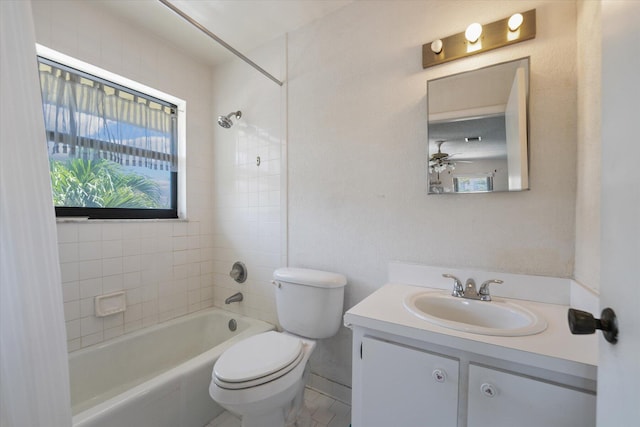 full bathroom with tile patterned flooring, tiled shower / bath, toilet, vanity, and ceiling fan