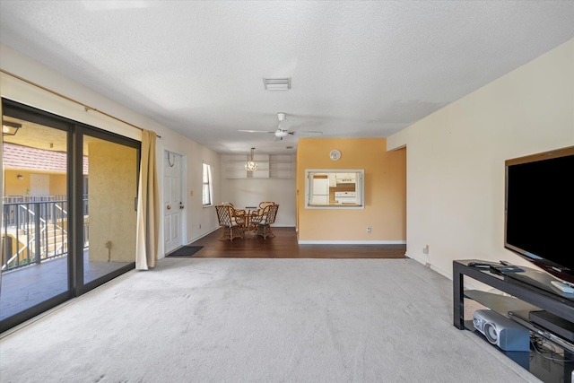 living room with carpet, ceiling fan, and a textured ceiling