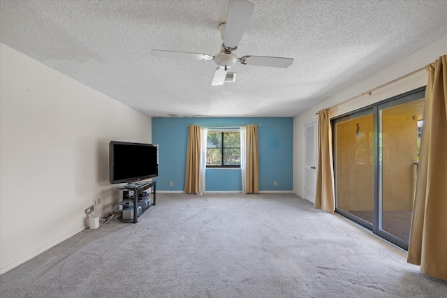 unfurnished living room featuring ceiling fan, light colored carpet, and a textured ceiling