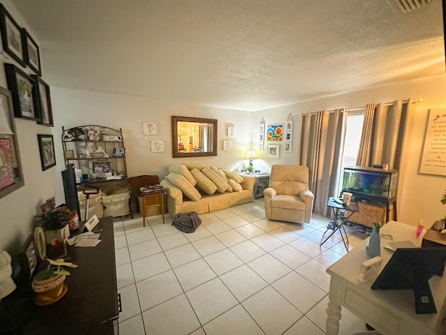 tiled living room featuring a textured ceiling