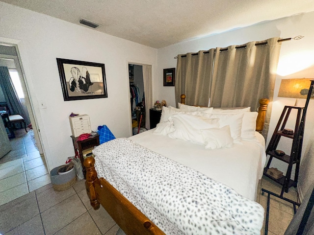 bedroom featuring light tile patterned floors, a closet, and a textured ceiling