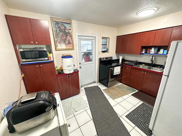 kitchen featuring stainless steel appliances, sink, and a textured ceiling