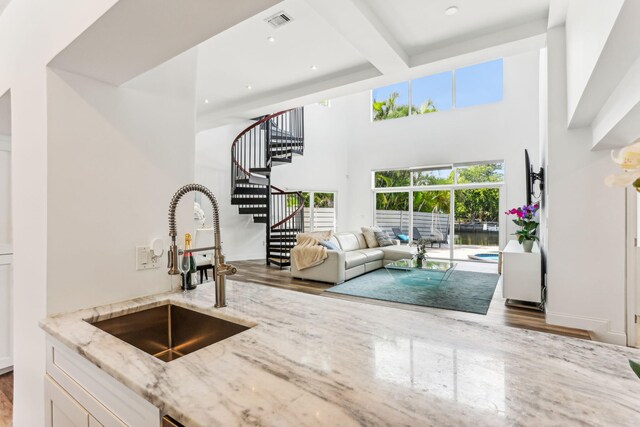 5533 Rico Dr, Boca Raton, FL 33487 - bar area featuring a sink, wood finished floors, stairway, a towering ceiling, and beamed ceiling