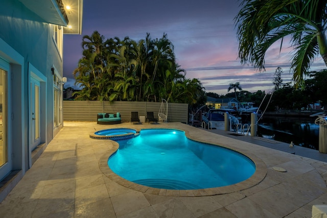 5533 Rico Dr, Boca Raton, FL 33487 - pool at dusk with a patio, a pool with connected hot tub, and fence