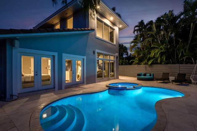 5533 Rico Dr, Boca Raton, FL 33487 - pool at dusk featuring french doors, a patio, a pool with connected hot tub, and fence