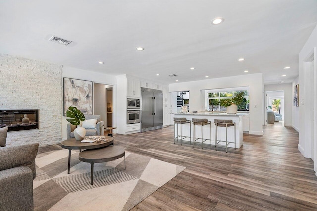 5533 Rico Dr, Boca Raton, FL 33487 - living area featuring recessed lighting, wood finished floors, a fireplace, and baseboards