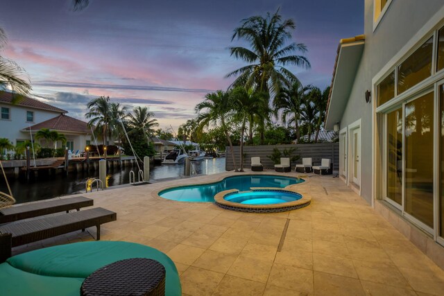 5533 Rico Dr, Boca Raton, FL 33487 - view of swimming pool with a patio area, a water view, a pool with connected hot tub, and fence