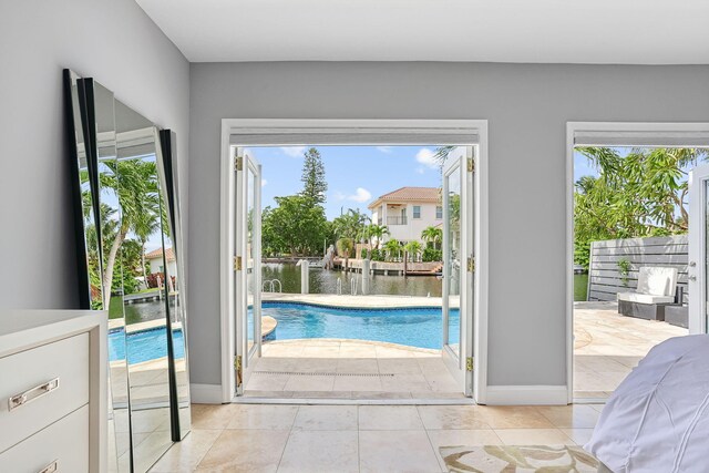 5533 Rico Dr, Boca Raton, FL 33487 - doorway to outside featuring plenty of natural light, light tile patterned floors, baseboards, and a water view