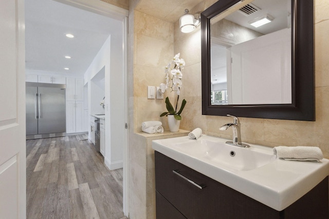 bathroom with vanity, tile walls, and hardwood / wood-style floors