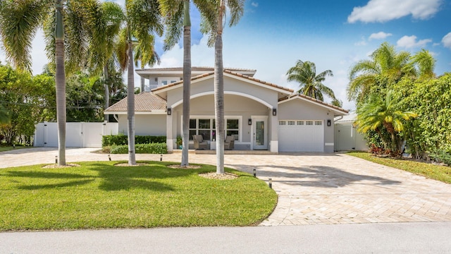 mediterranean / spanish house featuring a front yard and a garage