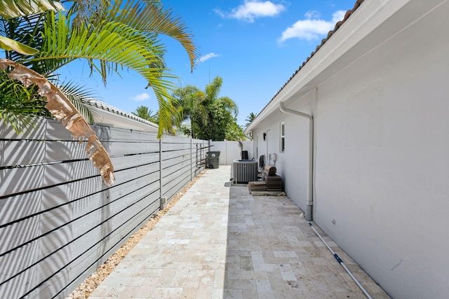 view of side of property with a patio and central AC