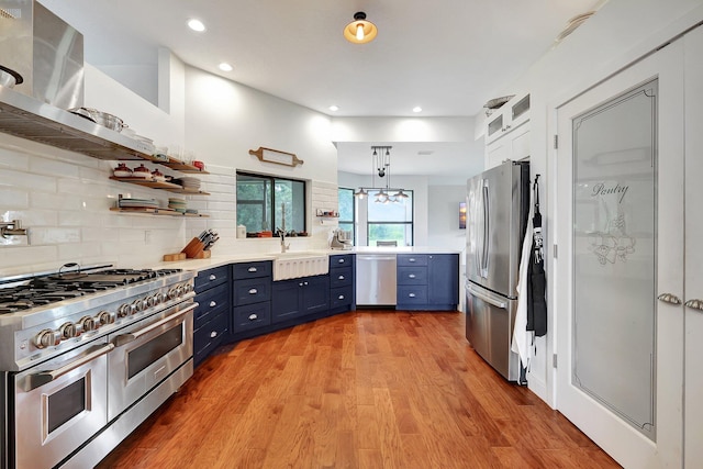 5890 NE 56th Pkwy, Okeechobee, FL 34972 - kitchen featuring light wood-style flooring, blue cabinetry, open shelves, light countertops, and stainless steel appliances