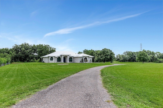 5890 NE 56th Pkwy, Okeechobee, FL 34972 - ranch-style house with stucco siding, gravel driveway, and a front lawn