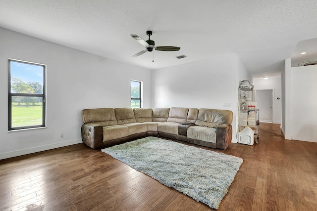 5890 NE 56th Pkwy, Okeechobee, FL 34972 - living area featuring visible vents, baseboards, a ceiling fan, a textured ceiling, and wood finished floors