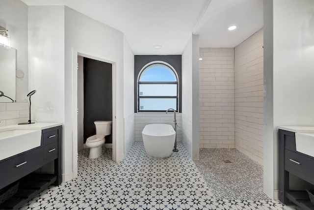5890 NE 56th Pkwy, Okeechobee, FL 34972 - full bathroom featuring vanity, a soaking tub, walk in shower, wainscoting, and tile walls