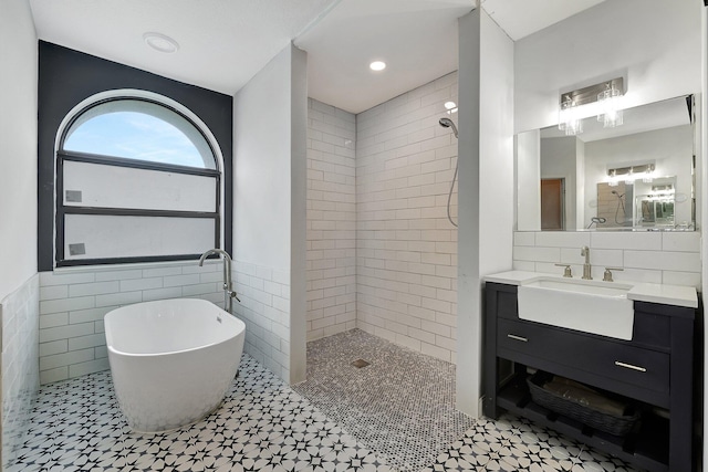 5890 NE 56th Pkwy, Okeechobee, FL 34972 - full bathroom featuring tile walls, a tile shower, a freestanding tub, and vanity