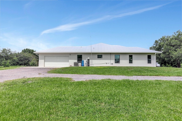 5890 NE 56th Pkwy, Okeechobee, FL 34972 - ranch-style home with central air condition unit, stucco siding, a front lawn, a garage, and driveway