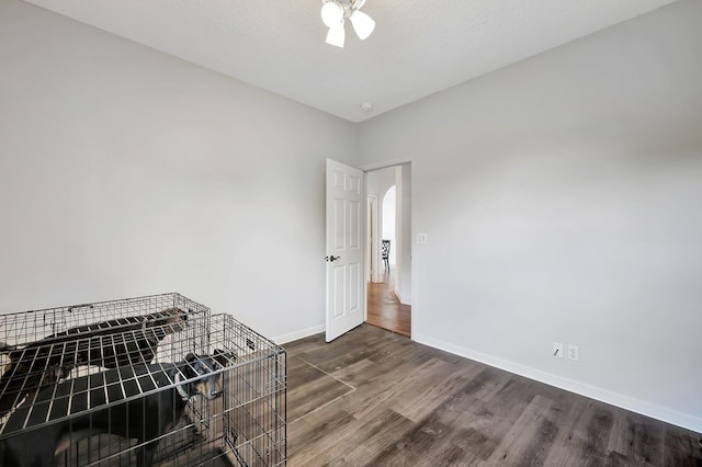 5890 NE 56th Pkwy, Okeechobee, FL 34972 - unfurnished room with arched walkways, dark wood-style flooring, baseboards, and a ceiling fan