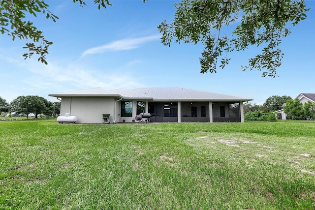 5890 NE 56th Pkwy, Okeechobee, FL 34972 - rear view of property with a yard, a sunroom, and stucco siding