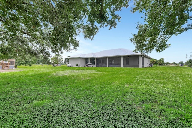 5890 NE 56th Pkwy, Okeechobee, FL 34972 - rear view of house featuring a yard and a sunroom