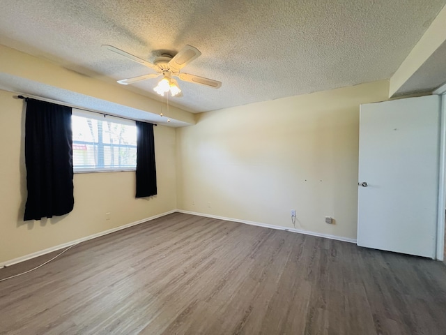 empty room featuring hardwood / wood-style flooring, a textured ceiling, and ceiling fan