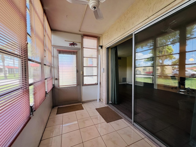 unfurnished sunroom featuring ceiling fan