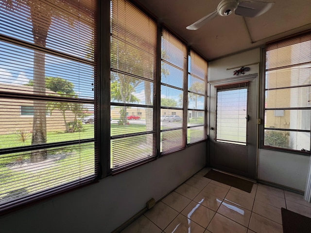 unfurnished sunroom featuring ceiling fan and a wealth of natural light